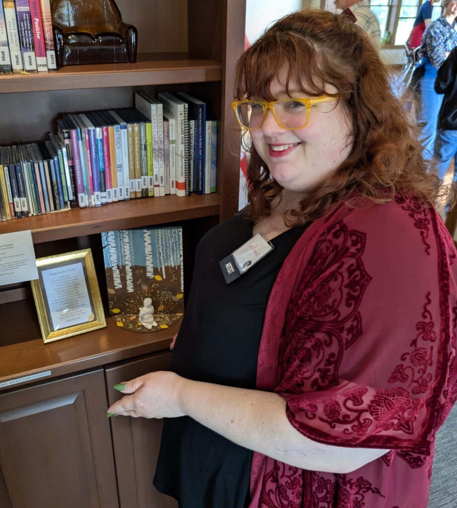 Alyssa poses with her art piece at the 2025 Community Art Show at Gilda's Club